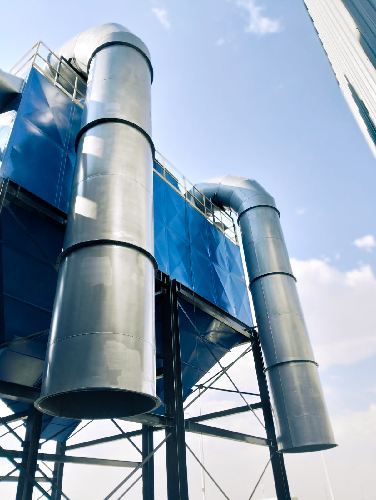 Fotografía de un sistema industrial de ductería y ventilación instalado en una planta del sector maderero. El equipo está diseñado para la recolección y filtración de aserrín y polvo fino generado en procesos de corte, lijado y mecanizado de madera, asegurando la calidad del aire y el cumplimiento de normas ambientales y de seguridad.