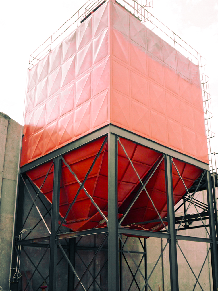 Instalación de colector de polvo industrial en planta con estructura metálica roja – MCAT.