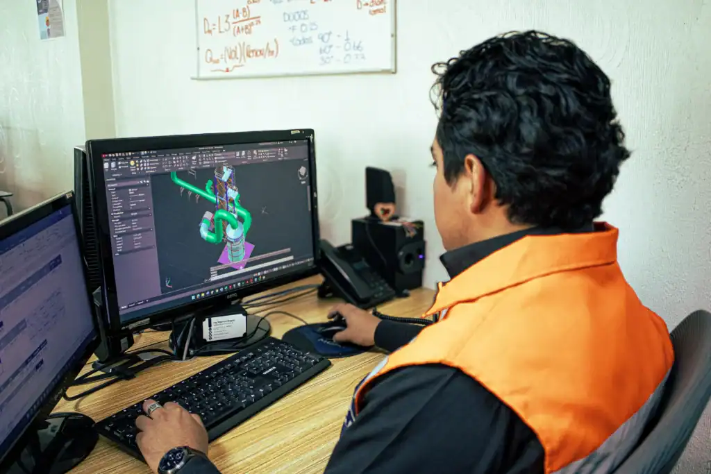 Ingeniero de MCAT diseñando un colector de polvos industrial en computadora